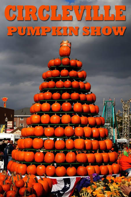 Tall pyramid shaped pile of pumpkins and a message promoting the Circleville Pumpkin Show 2026
